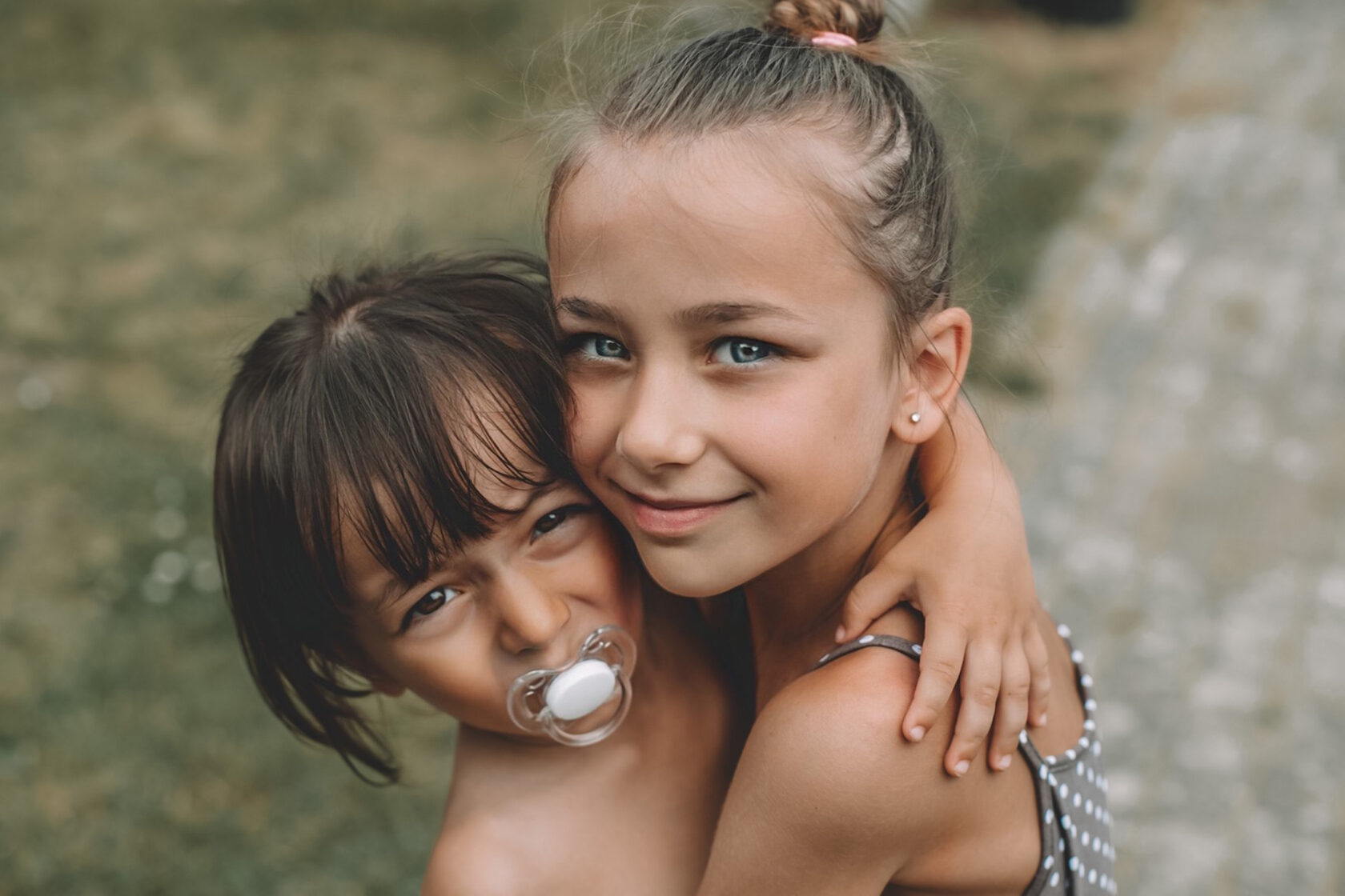 Two children embracing outdoors